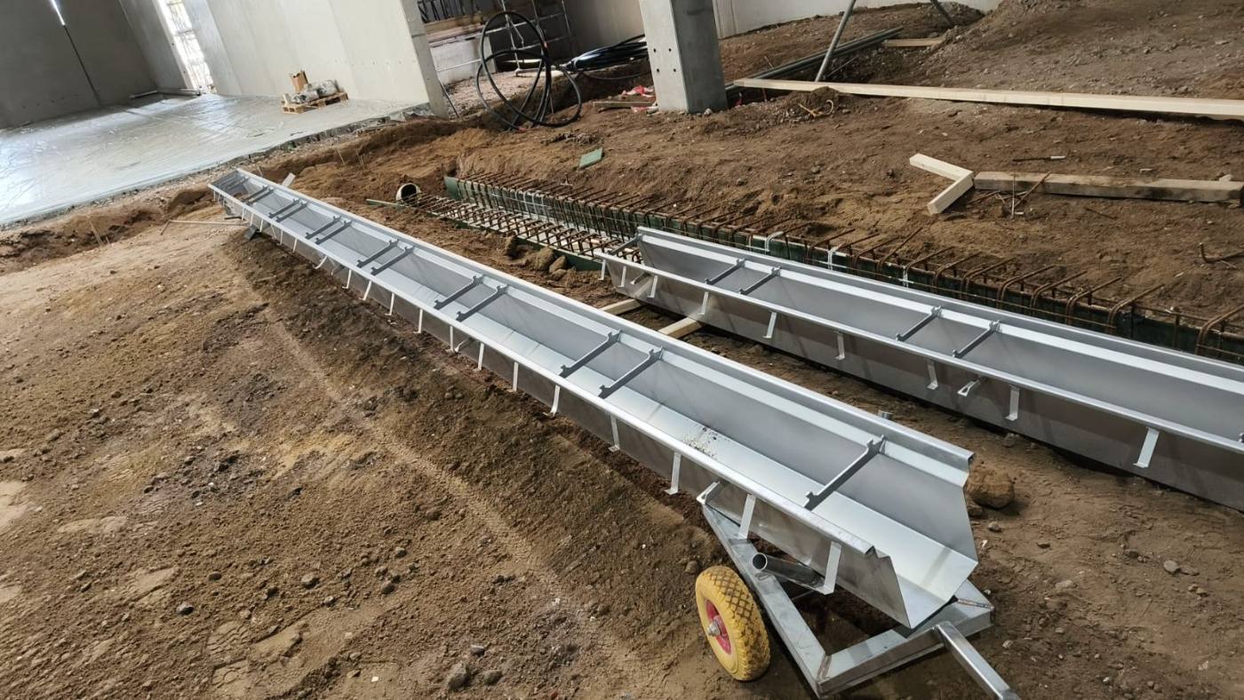Prefab RVS vloergoten aangevoerd en klaargezet naast de betonfundatie