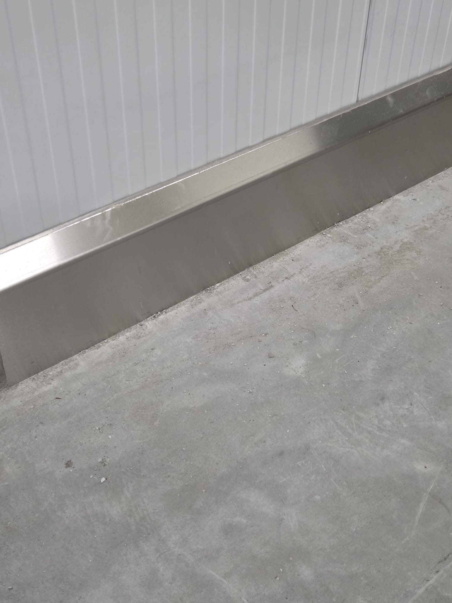 High-care RVS stootplint over bestaande betonnen plint, gevuld met gietmortel