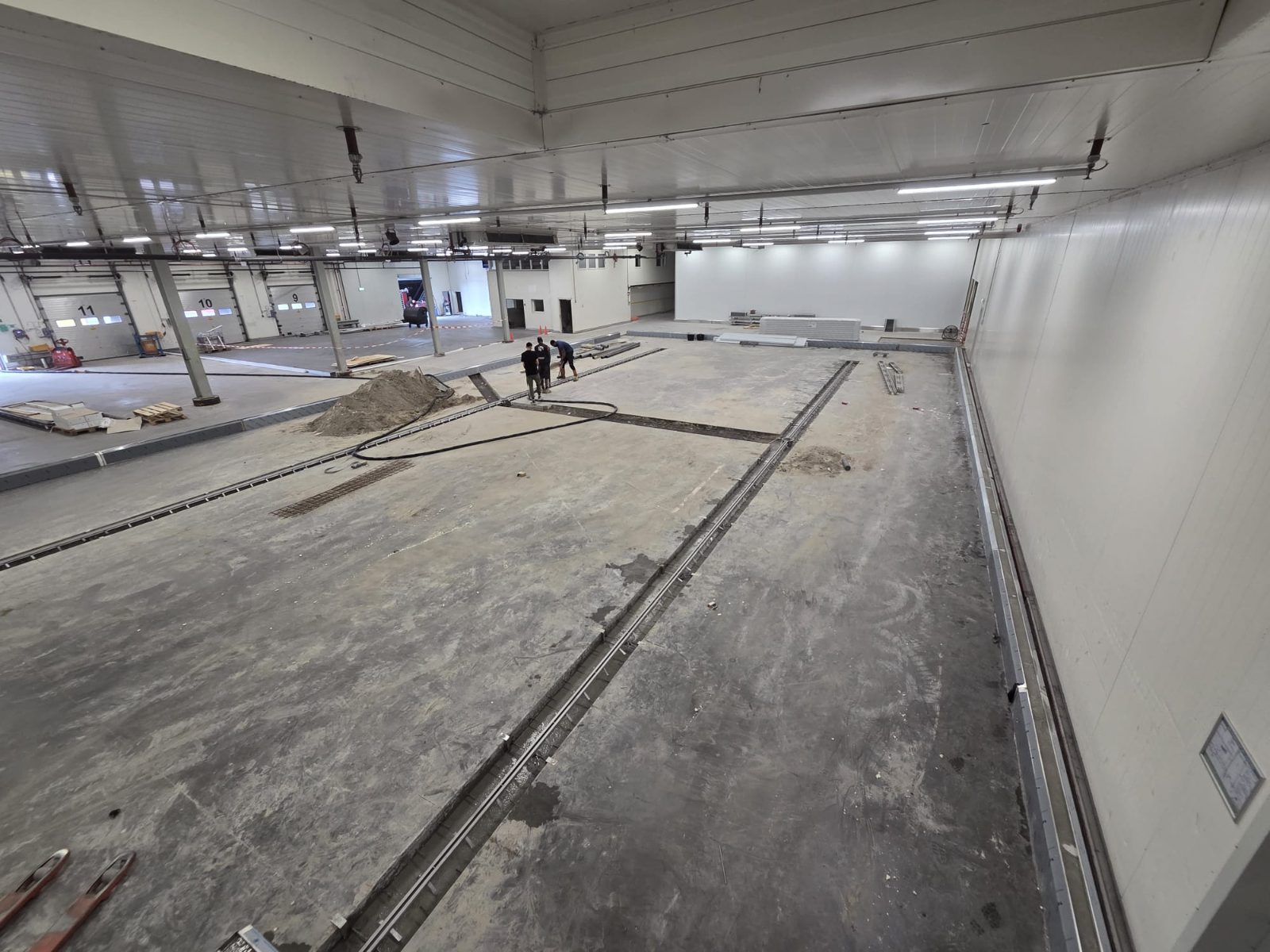 Uitgezaagde sparingen in de bestaande betonvloer voor nieuwe RVS vloergoten bij Van Koolen